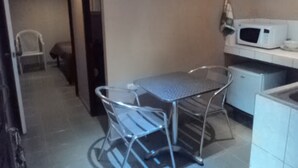 A small kitchenette with a microwave, a sink, and a chair. - Casa Maya (Monteverde)