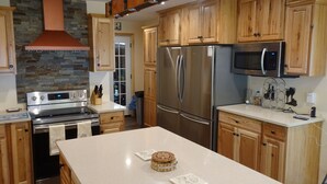 A modern kitchen with wooden cabinets, stainless steel appliances, and a central island. - September Dates Open! Year Round Fun For The Whole Family! Municipal Utilities (Honeoye)