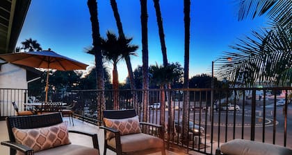 Sunny condo with loft and spacious patio surrounded by palm trees
