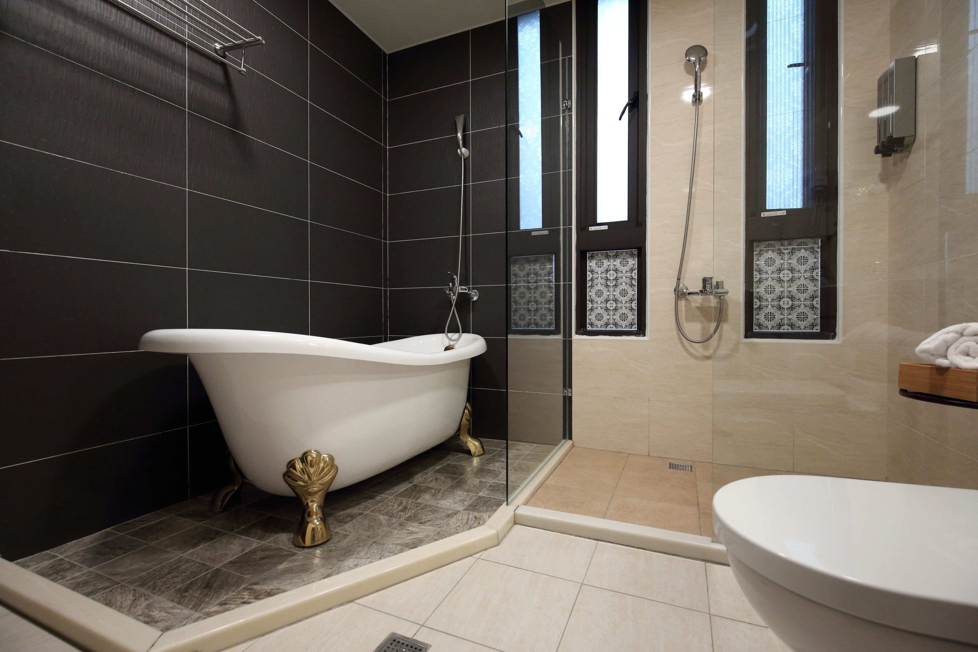 A modern bathroom with a freestanding bathtub, a glass-enclosed shower, and a separate toilet area.