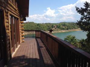 A wooden deck with a view of a lake and forested hills. - Serenity view of Douglas Lake (Sevierville)