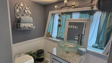 Une petite salle de bain comprenant des toilettes, un lavabo et un meuble-lavabo.
