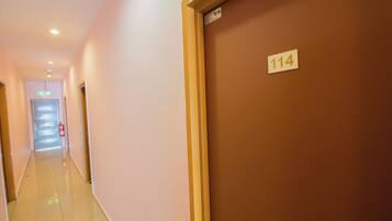 A hotel corridor with a sign indicating room number 114.