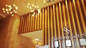 A reception area with a modern design, featuring a wooden slat wall and a chandelier. - JB Town Executive Suite (Johor Bahru)