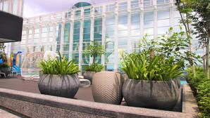 A modern building with large glass windows and potted plants in front. - JB Town Executive Suite (Johor Bahru)