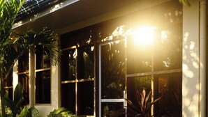 A house with a covered porch, large windows, and a gravel driveway. - Don Remegio Villas (General Luna)