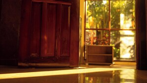 A wooden door leading to a room with a large window. - Don Remegio Villas (General Luna)