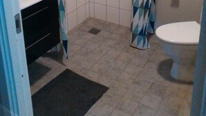 A small bathroom with a shower, toilet, and sink.