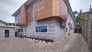 A multi-story building with a modern design, featuring a large window and air conditioning units on the exterior. - BoardWalk Hotel Wuse 2 (Abuja)