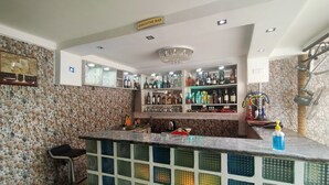 A bar area with a stone wall, a sign for the executive bar, shelves with bottles, and a bar counter. - BoardWalk Hotel Wuse 2 (Abuja)