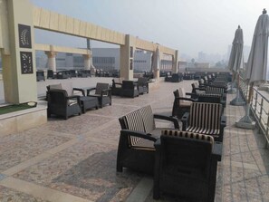 A rooftop terrace with outdoor seating and umbrellas. - Horizon Loaloat El Nile (Cairo)