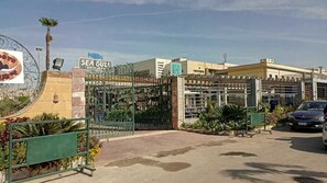 A gated entrance with a sign for 'Sea Gull Restaurant' and a parking area with a car. - Horizon Loaloat El Nile (Cairo)