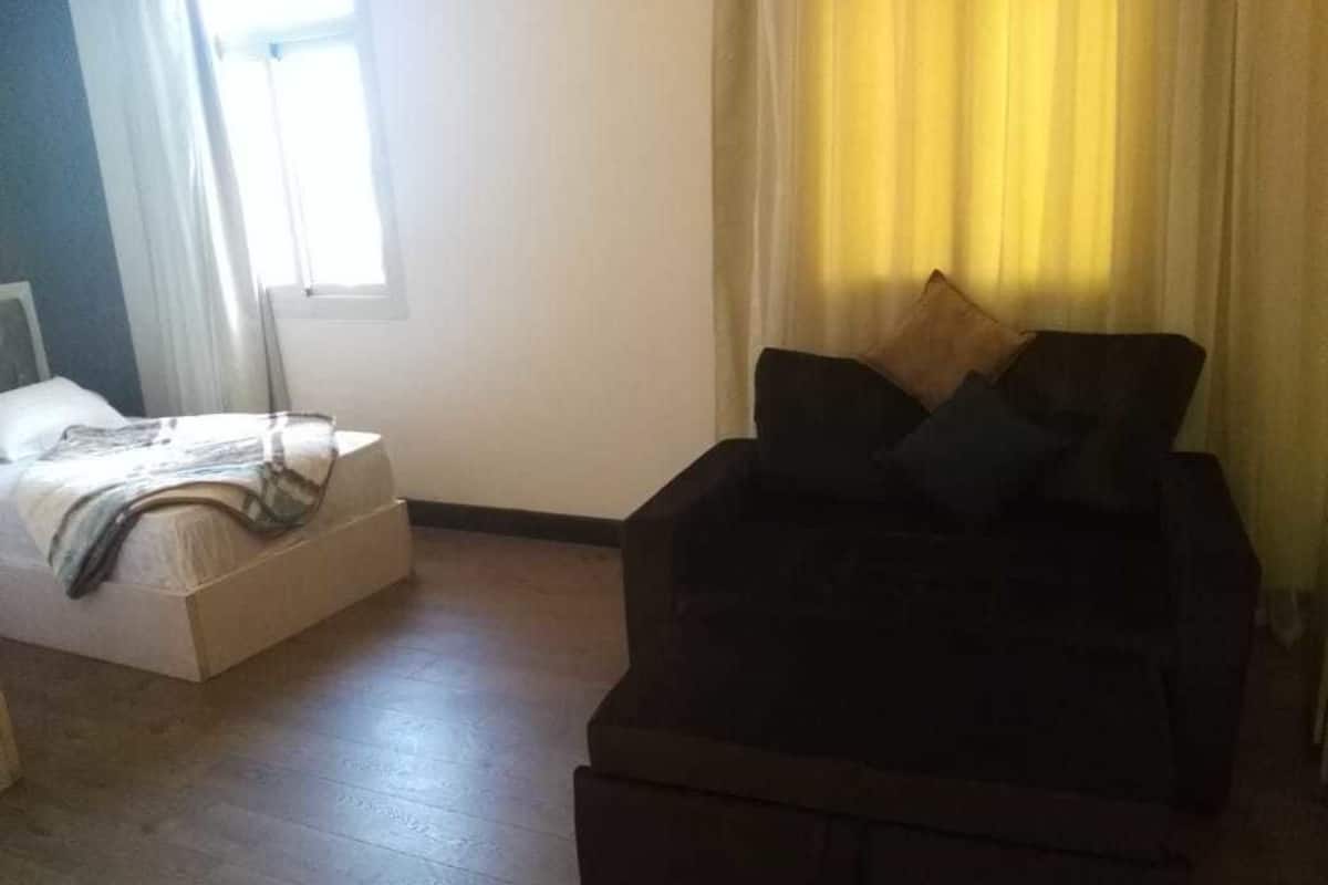 A living room with a sofa and a bed.