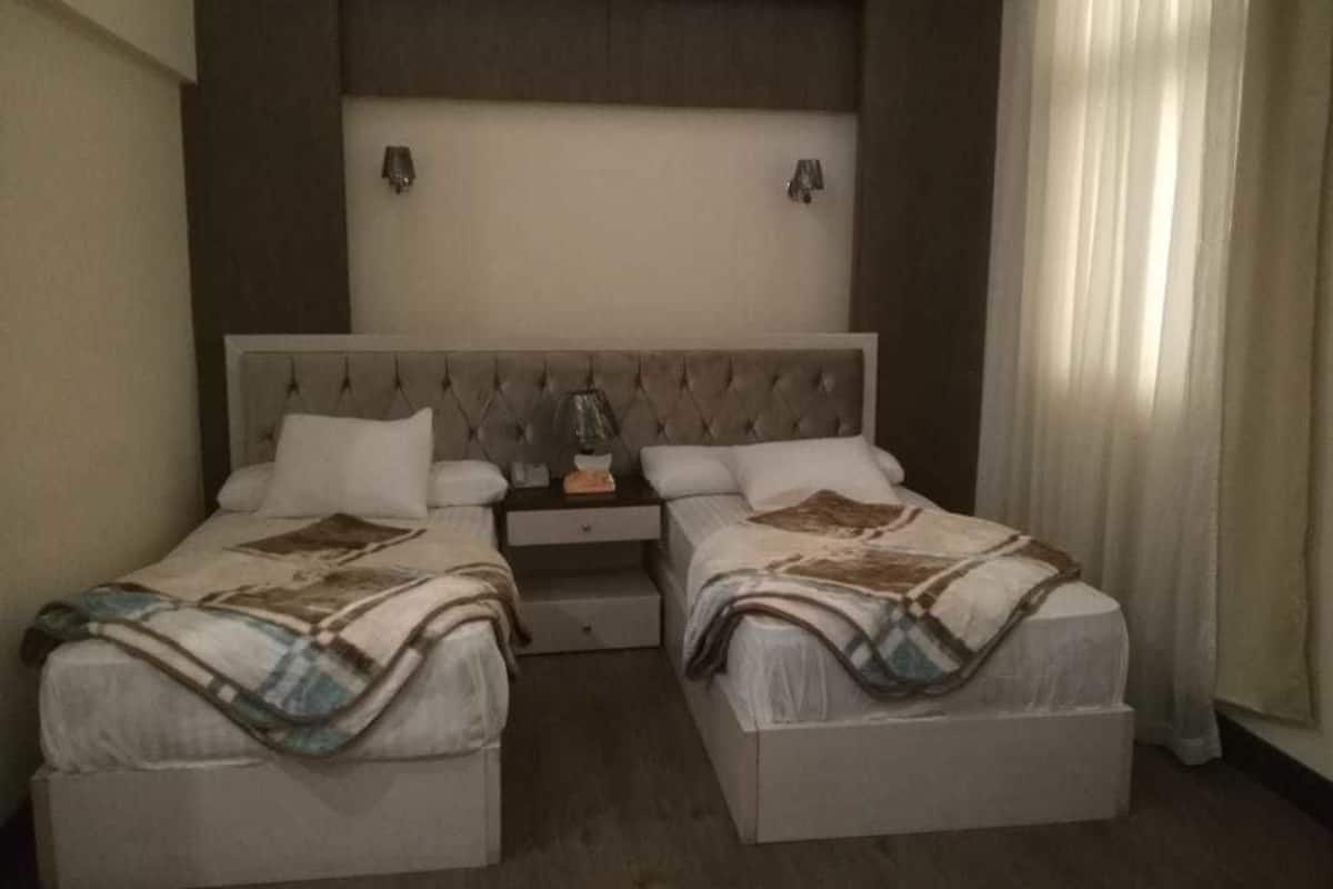 A double bed with a tufted headboard, two bedside tables, and a nightstand.