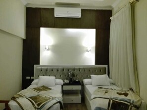 A hotel room with a bed, a nightstand, a mirror, and a window with curtains. - Horizon Loaloat El Nile (Cairo)