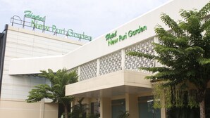 Hotel New Puri Garden, con una fachada moderna, delicados celosías decorativas y abundante vegetación.