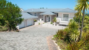 A two-story house with a paved driveway and a well-maintained garden. - 8 Sheerline (Knysna)