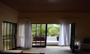 Ein Zimmer mit einer Schiebetür zum Balkon, auf dem eine rote und weiße Couch steht.