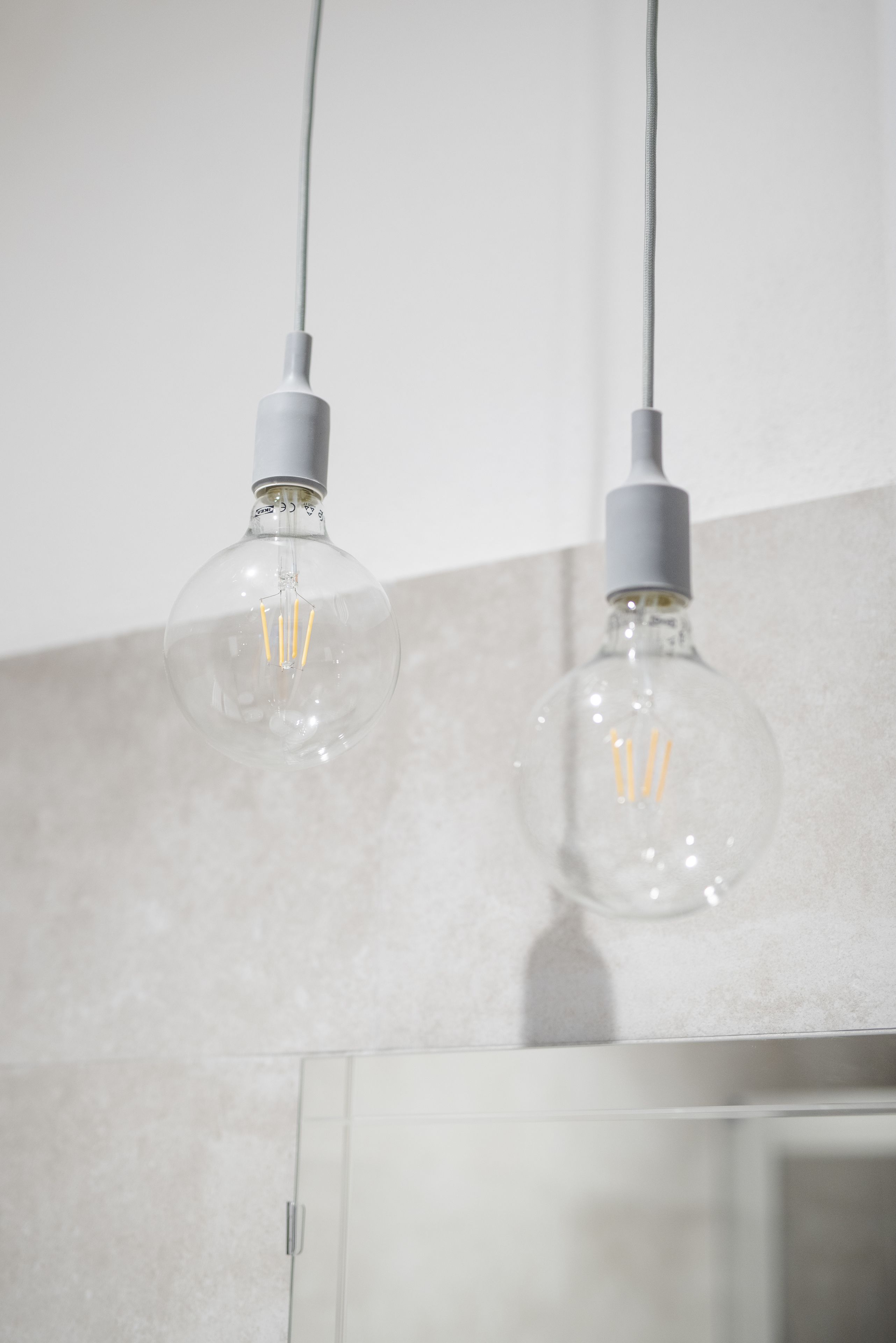 Two clear glass pendant lights with visible filament bulbs hanging from a ceiling.