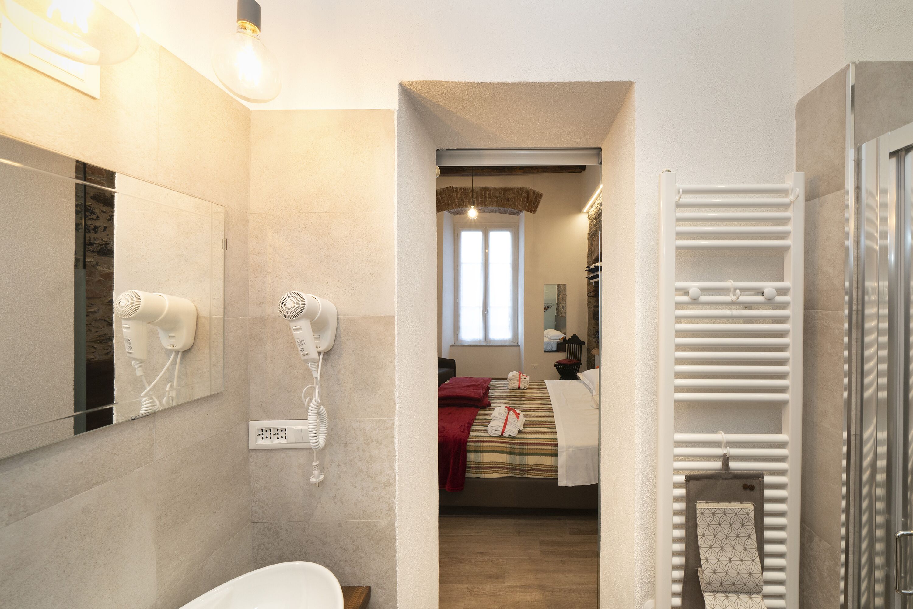Un baño moderno con ducha, secador de pelo y barra para toallas.
