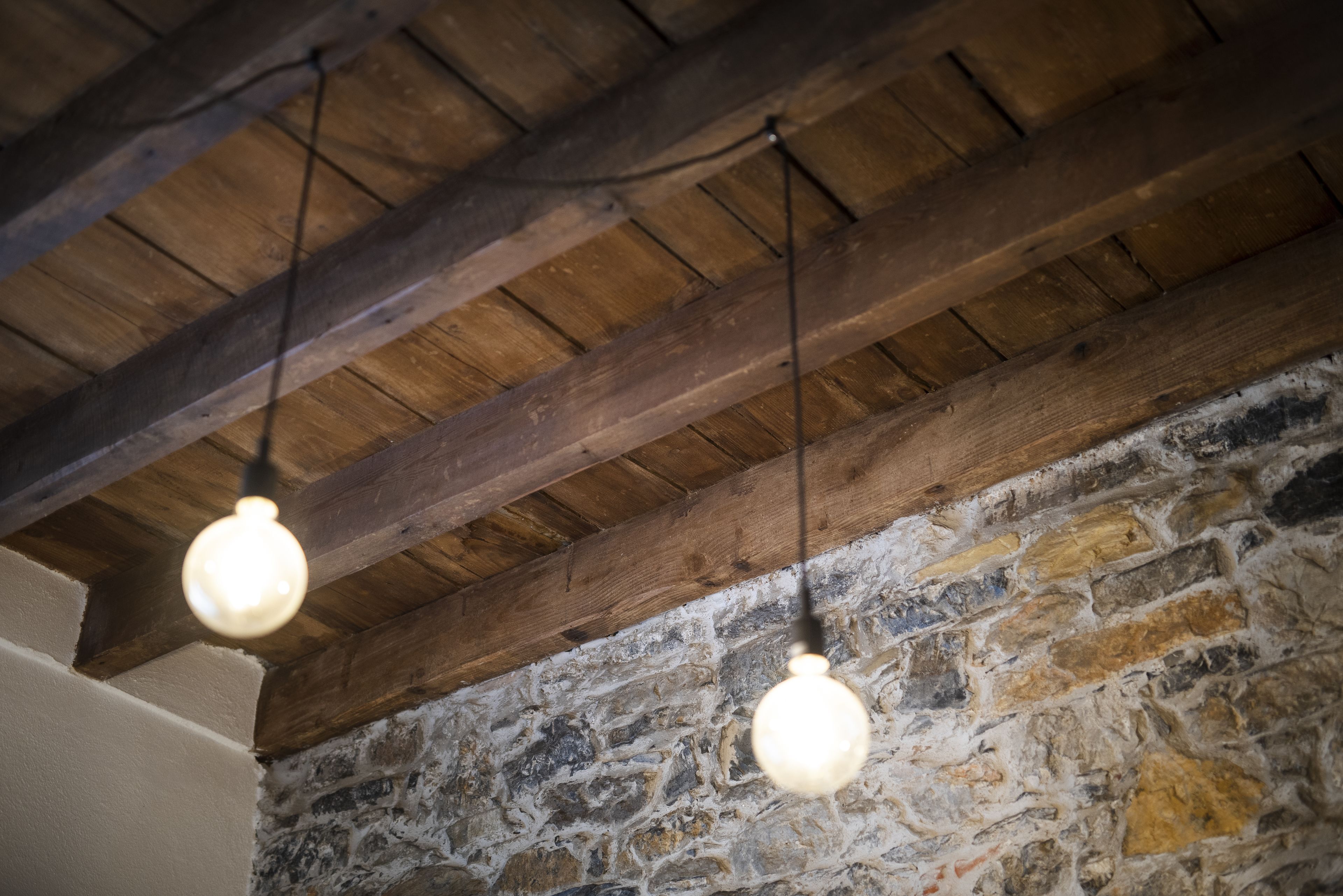 Een rustiek interieur met zichtbare houten balken en een stenen muur.