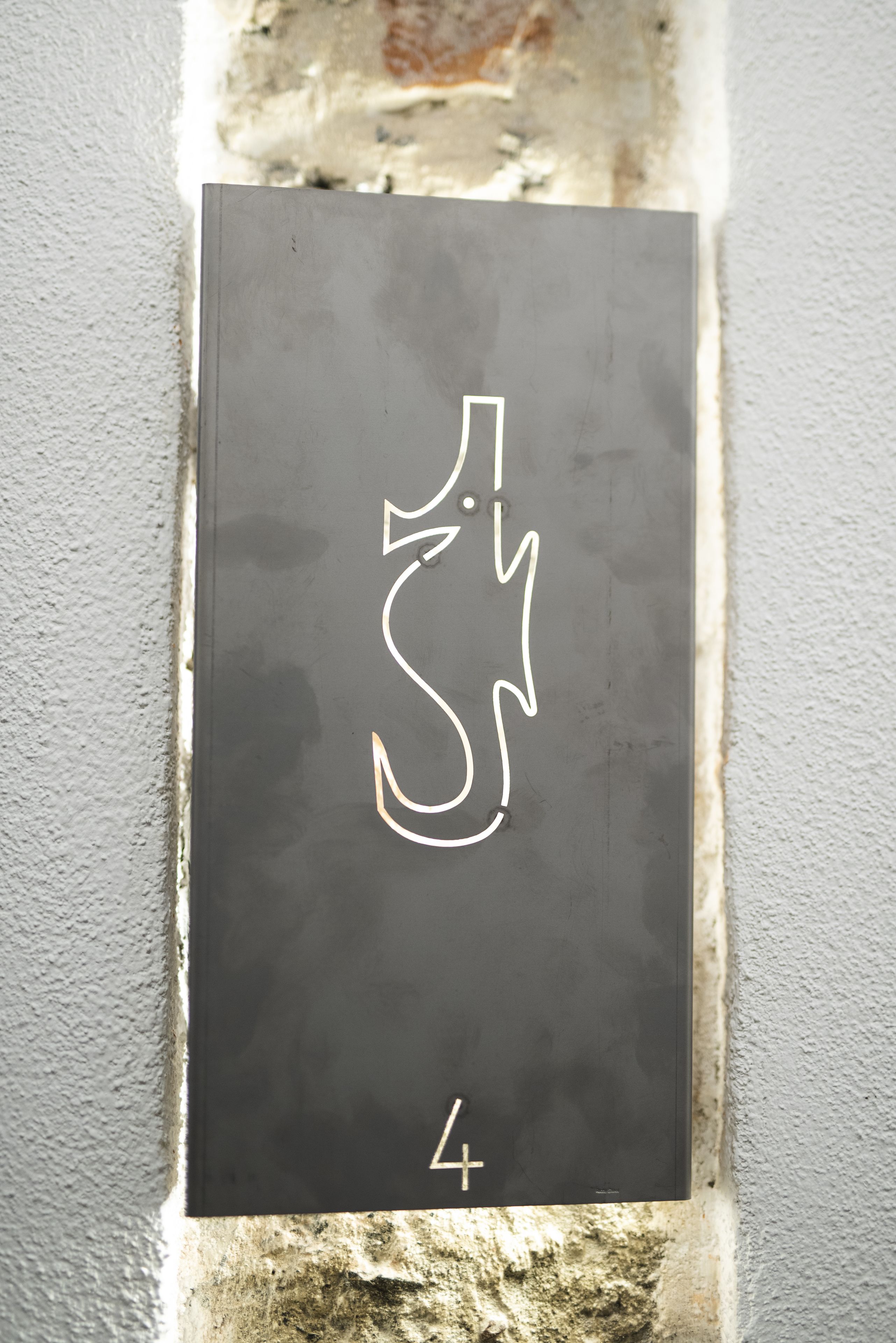 A black sign with a white symbol and the number 4.