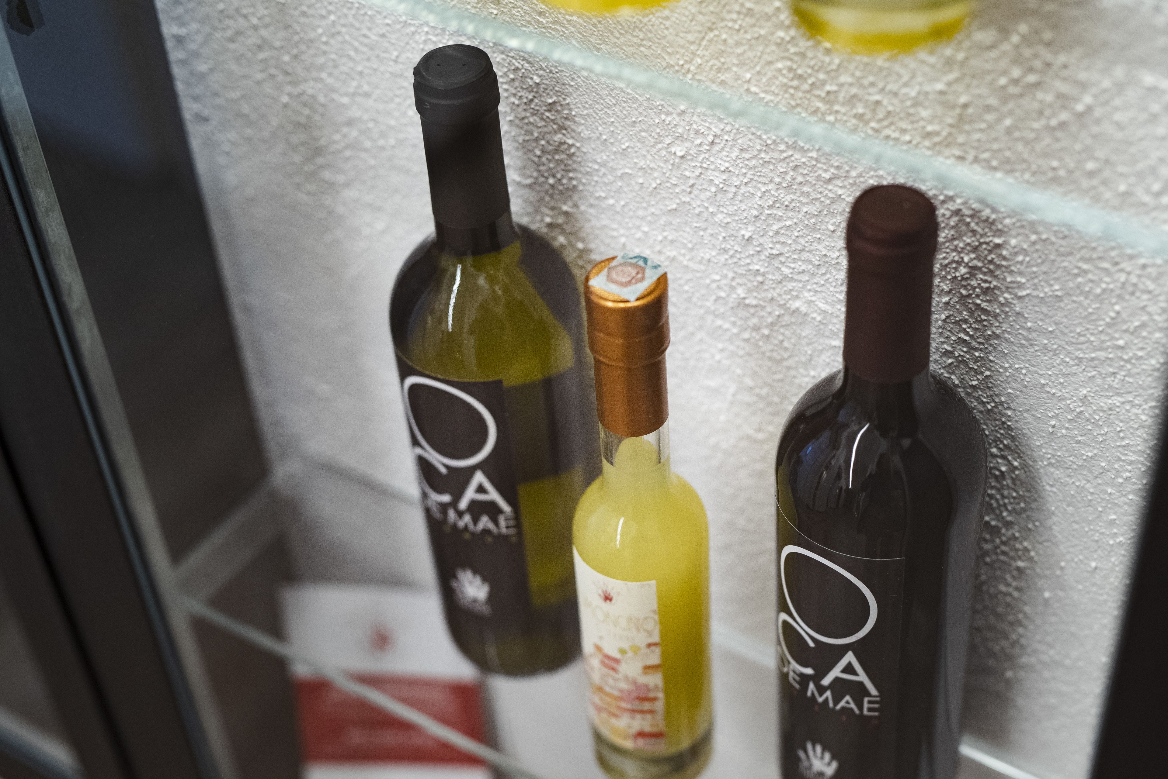 Trois bouteilles de vin dans un réfrigérateur.
