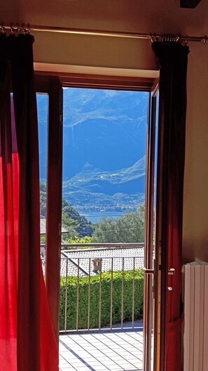 A room with a view of a coastal landscape through an open door. - Holideal Casa Barbara (Tremosine)