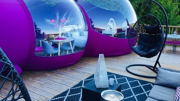 Two transparent spherical structures with seating inside, a hanging chair, and a decorative cone on a wooden deck. - La Bulle Des Anges (Illoud)