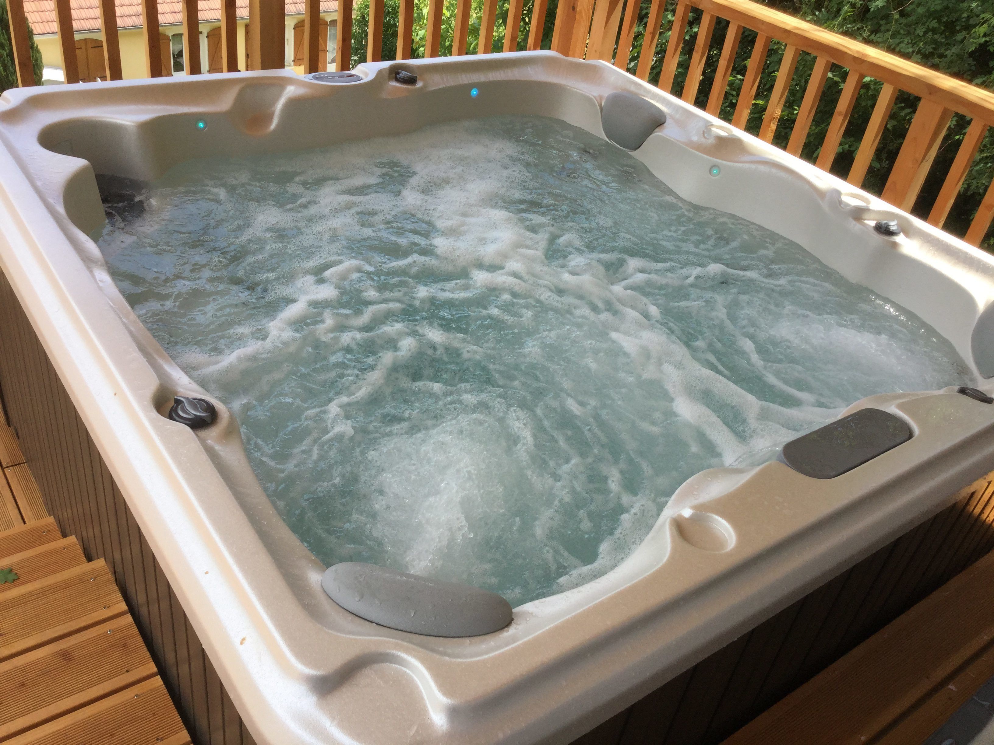 A hot tub with a wooden deck surrounding it.