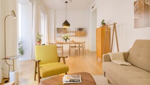 A modern living room with a yellow armchair, a beige sofa, and a wooden coffee table.