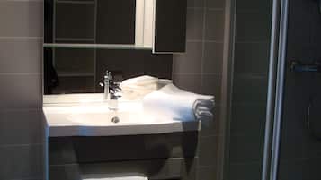 A bathroom with a sink, mirror, and towel rack.