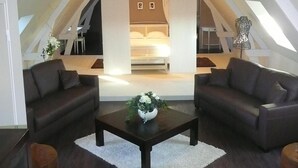 Ruime loft slaapkamer met een hoge plafond, een groot bed en uitzicht op de woonruimte.