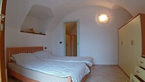 A bedroom with a bed, a wardrobe, and a ceiling light. - Holideal Casa Lauretta (Tremosine)