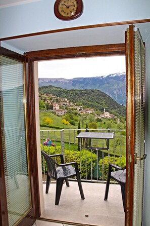 A balcony with a view of a mountainous village.