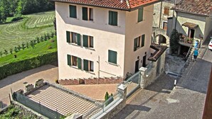 A building with a checkered pavement courtyard, a stone wall, and a view of a mountainous landscape. - Holideal Casa Lauretta (Tremosine)