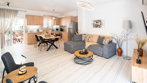 En moderne lejlighed med spiseplads, køkken og opholdsstue.
