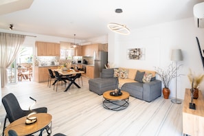 A modern apartment with a dining area, kitchen, and living space.