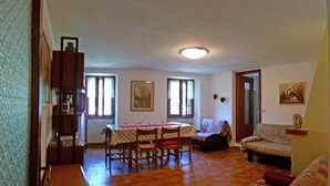 A dining area with a table and chairs, a sofa, and a radiator. - Holideal Casa Luisa (Tremosine)