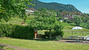 A grassy area with a gazebo, a table with chairs, and a fence. - Holideal Casa Luisa (Tremosine)