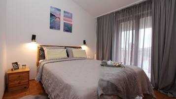 Een slaapkamer met een groot bed, een houten nachtkastje en een klein vloerkleed.