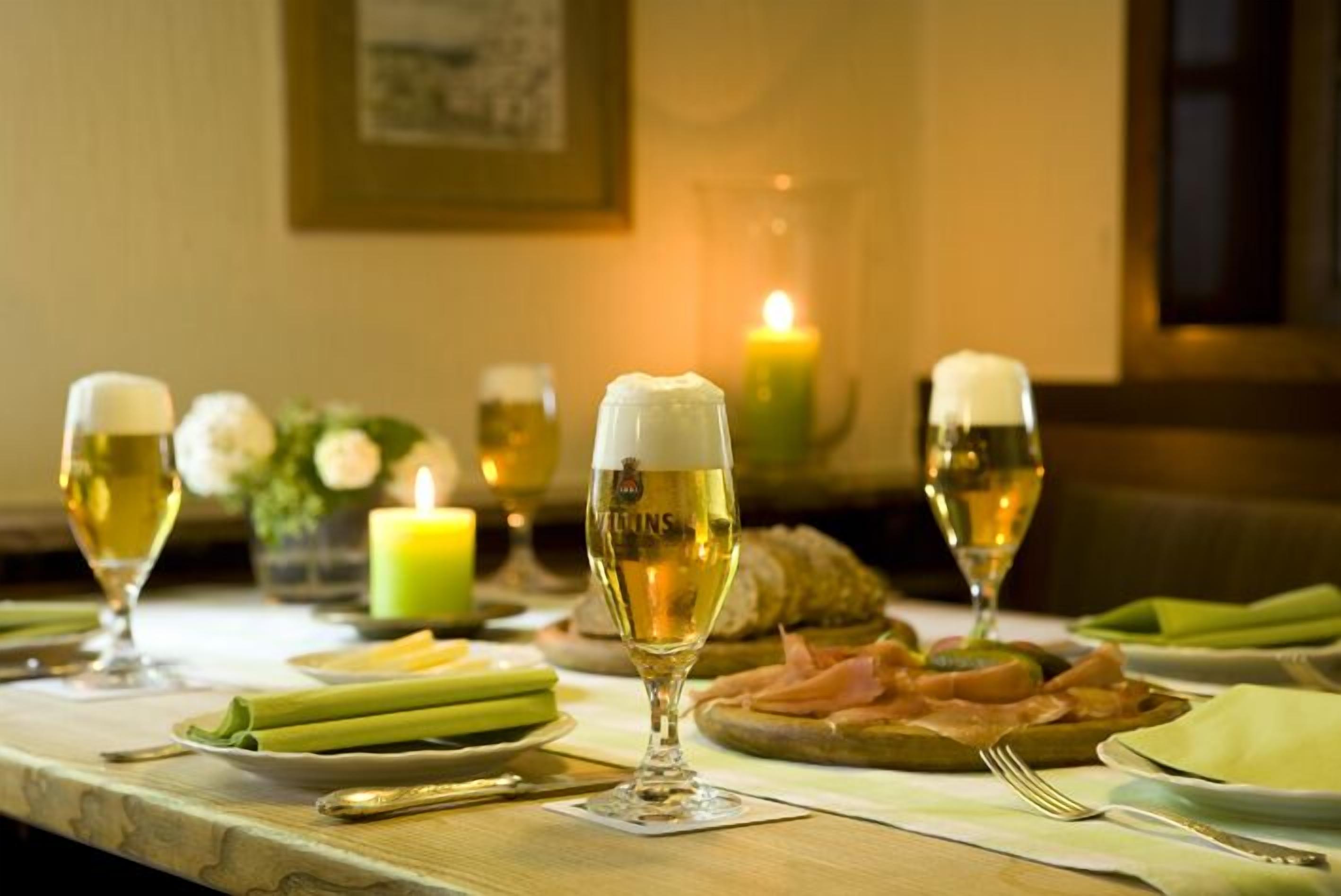 A table set for a meal with wine glasses, a candle, and food.