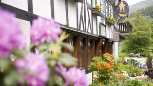 Een traditioneel vakwerkhuis met balkon en bloembakken.
