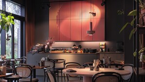 A modern restaurant with a central island, seating around it, and a view of the city through large windows. - lyf East Frankfurt (Frankfurt)