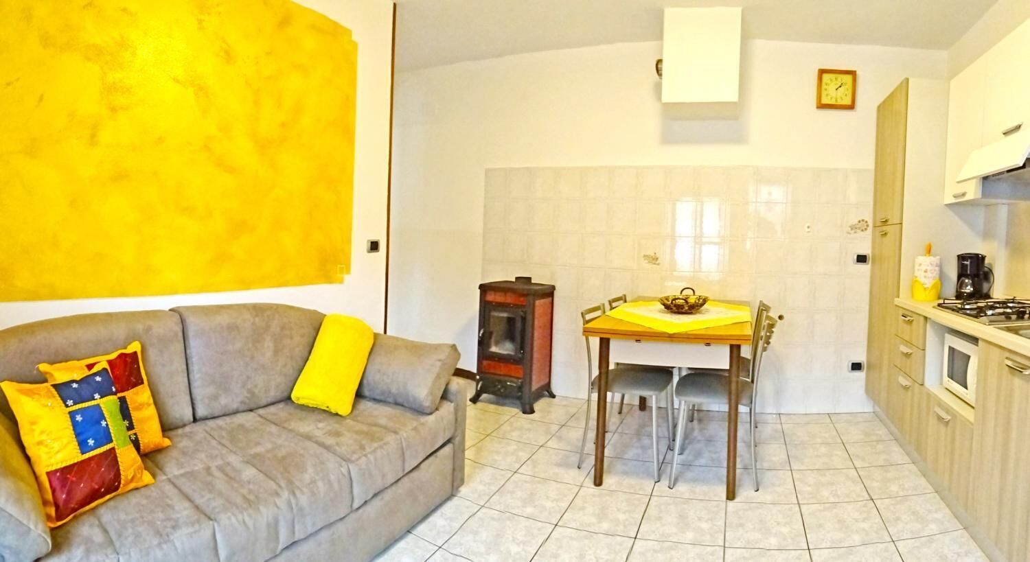 A compact living space with a sofa, a dining table, and a kitchen area.