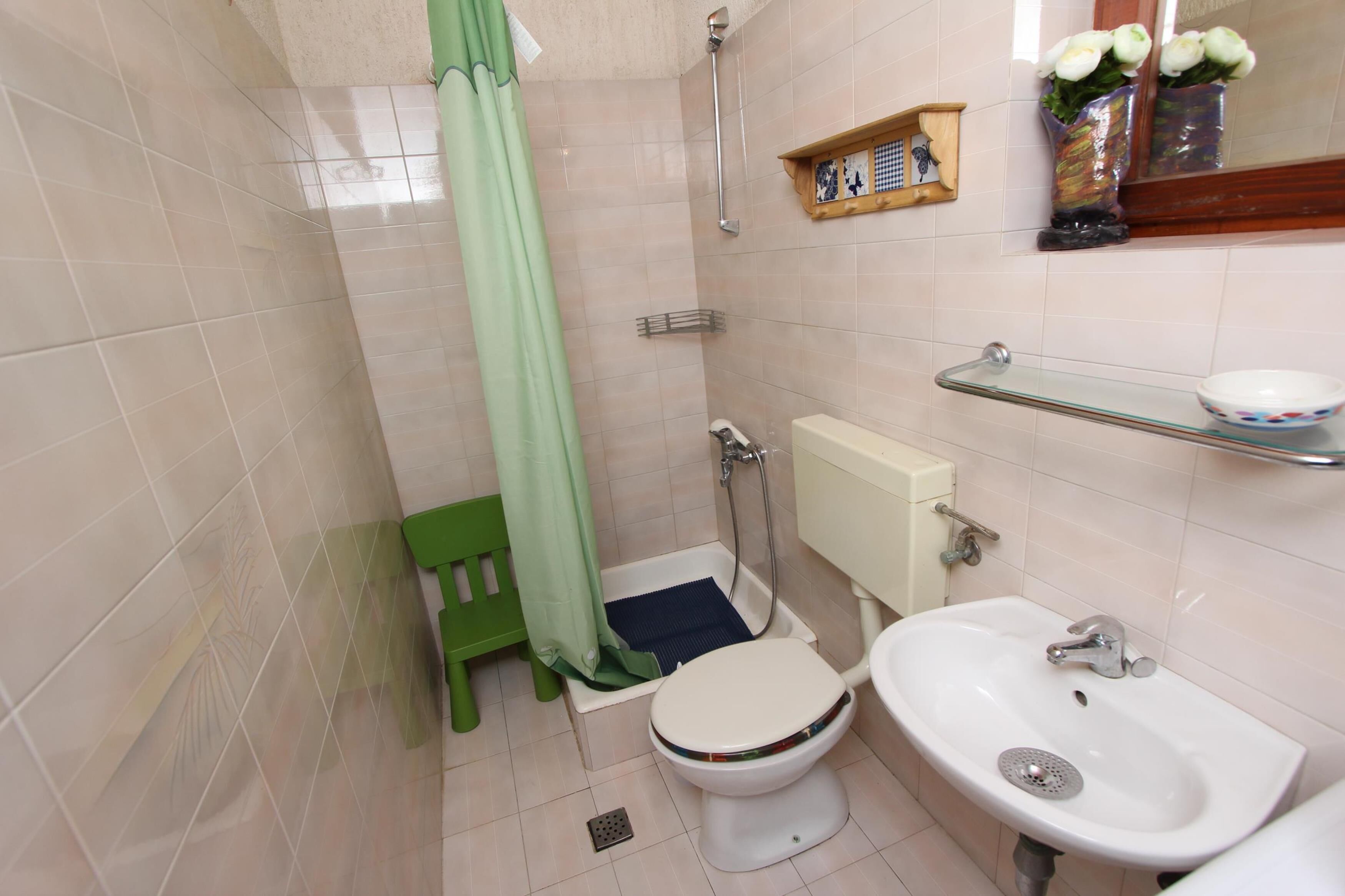 A bathroom with a toilet, bidet, sink, and shower.