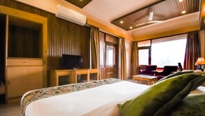 Una habitación de hotel con una cama, televisión, escritorio y una silla.