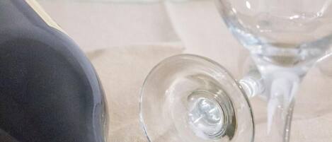 A bottle of white wine and an empty wine glass on a table.