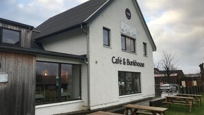 A building with a sign reading "Café & Bunkhouse." - An Cala Cafe and Bunkhouse - Hostel (Lochinver)