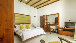 A bedroom with a bed, a desk, a chair, a television, and a mirror. - Cogent Holiday Home (Udunuwara)